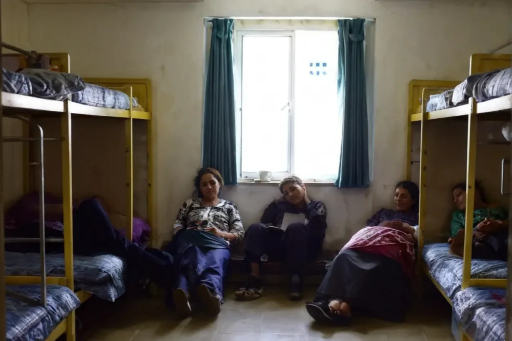 Personas descansando en un albergue temporal, compartiendo historias y apoyo mutuo.