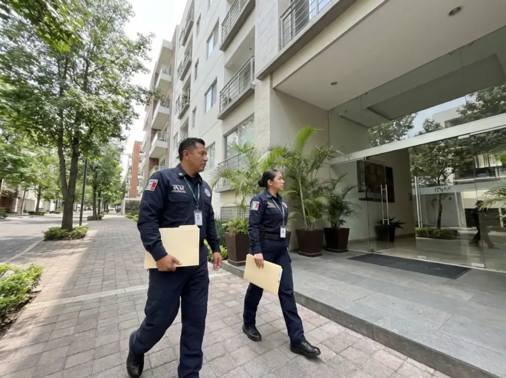 Agentes federales de migración del INM llegando a edificio residencial para verificación