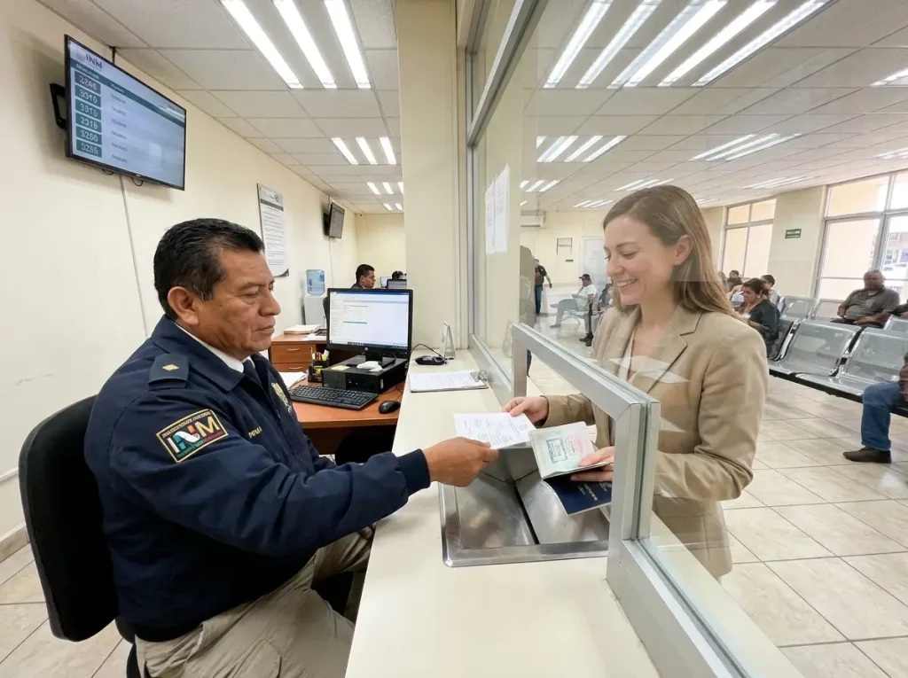 Oficial del INM completando trámite de visa de trabajo para solicitante extranjera en ventanilla del INM